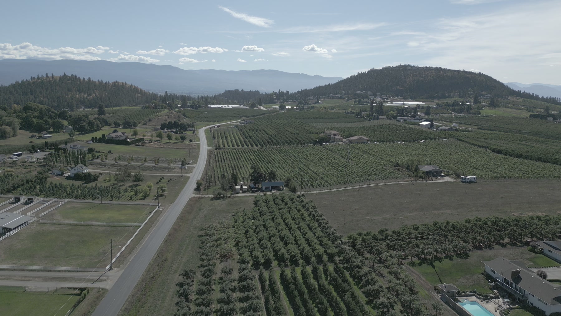 Aerial view of orchards, roads and rolling Okanagan terrain