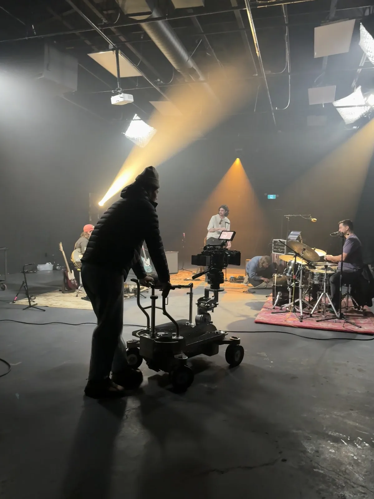 Camera operator silhouetted against a lit Nightshades stage setup
