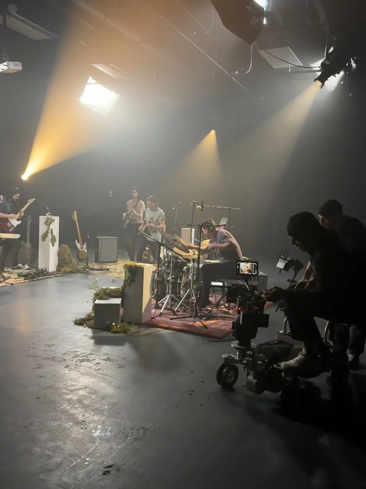 Silhouetted camera and crew beside the Nightshades performance set