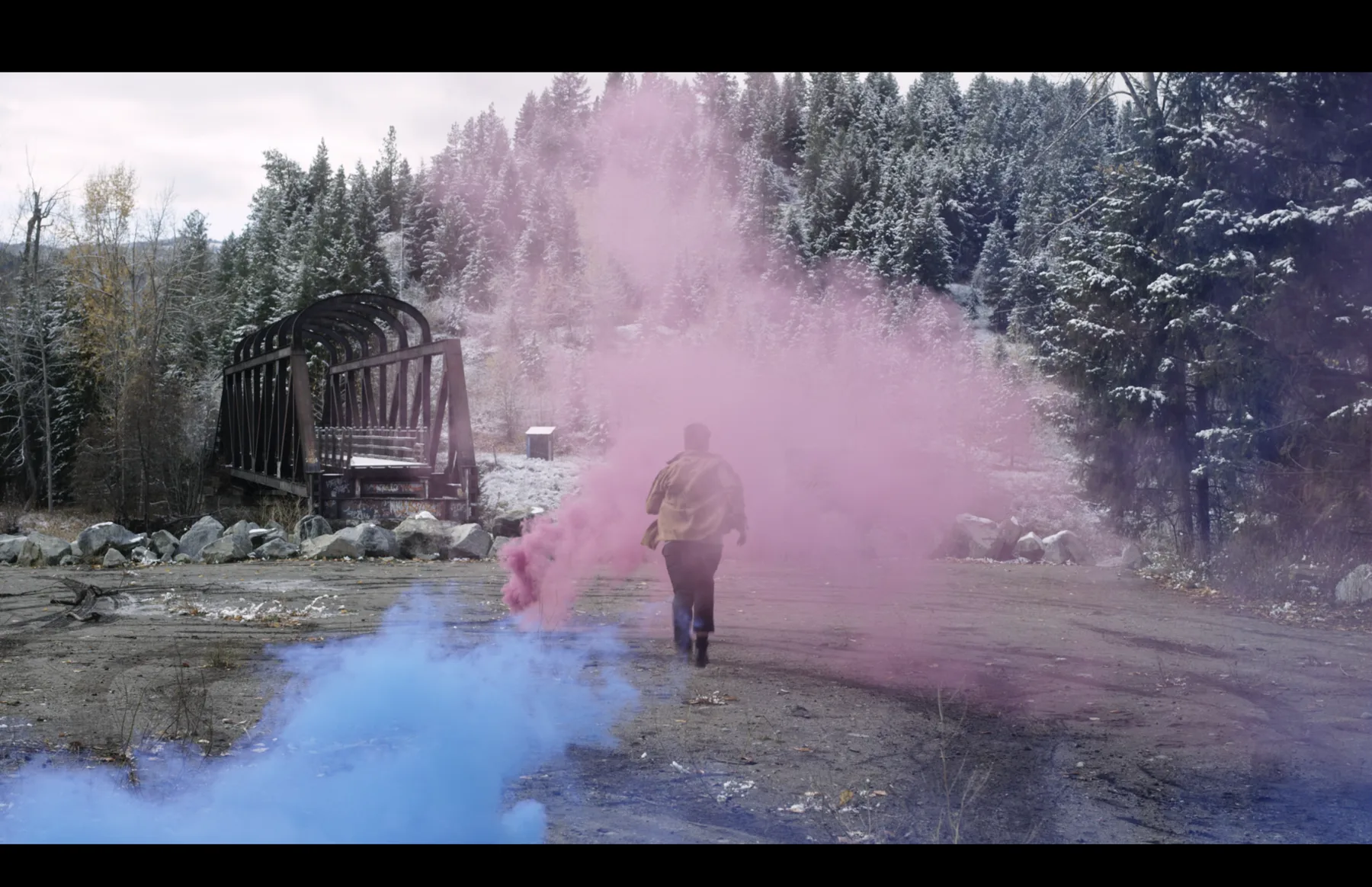 Actor walking through coloured smoke beside a bridge in Princeton