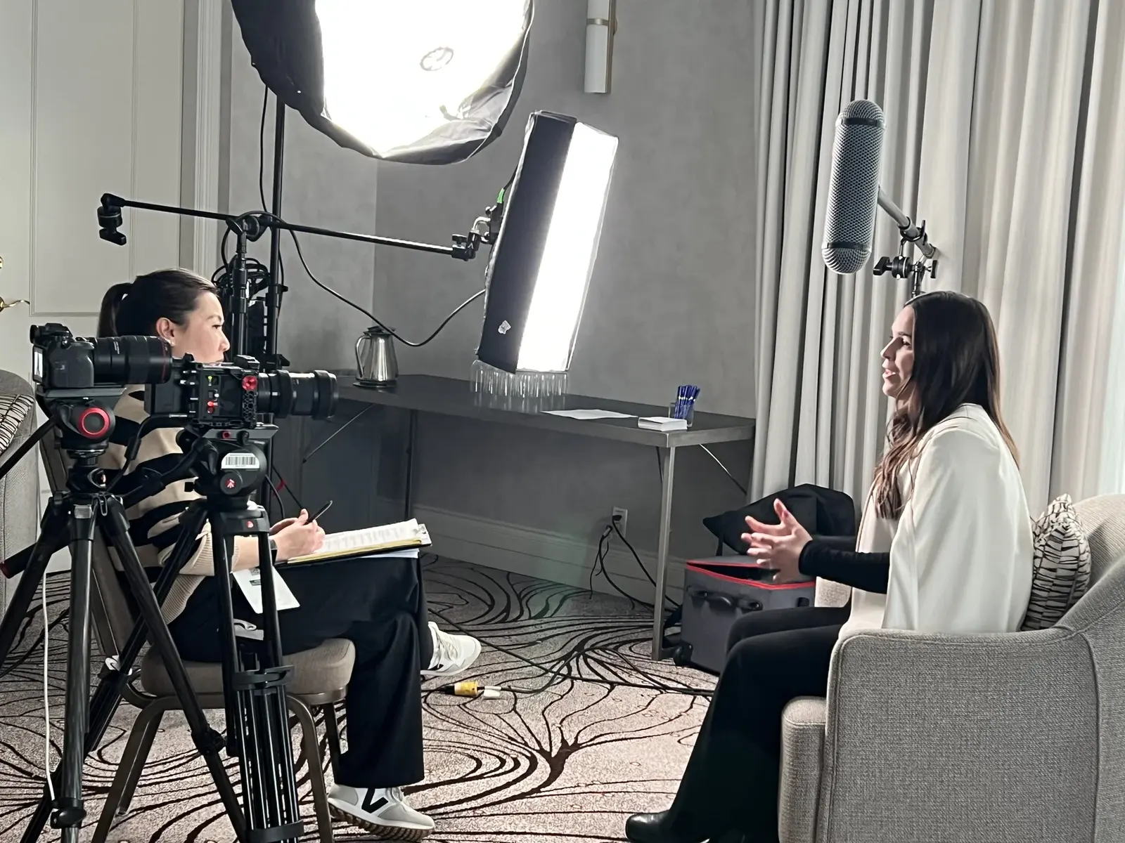 Over-the-shoulder view of the SandBay interviewer, camera, lights and seated subject