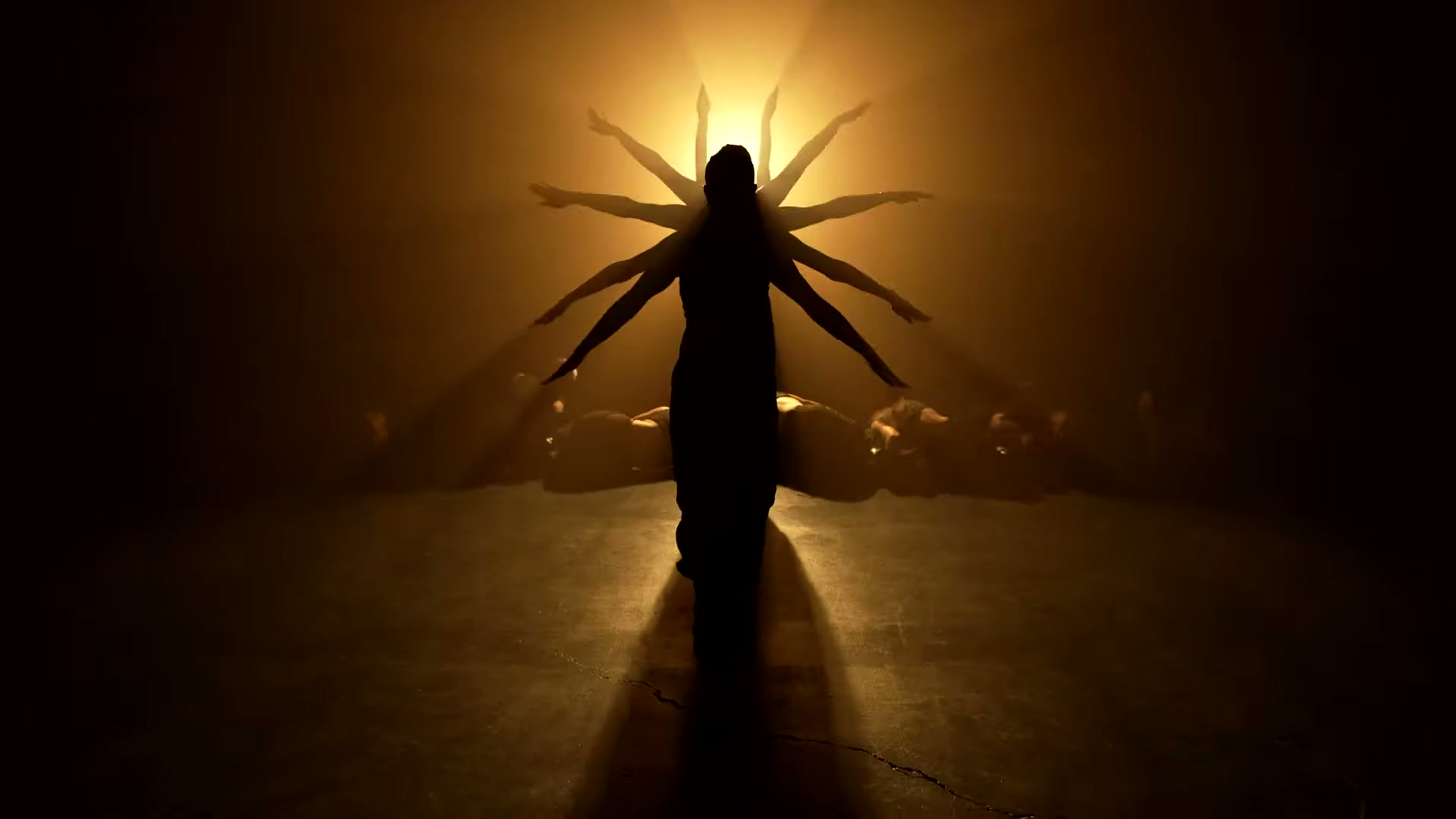 The Village Dance Academy's Sockeye ensemble forms a many-armed silhouette in amber backlight